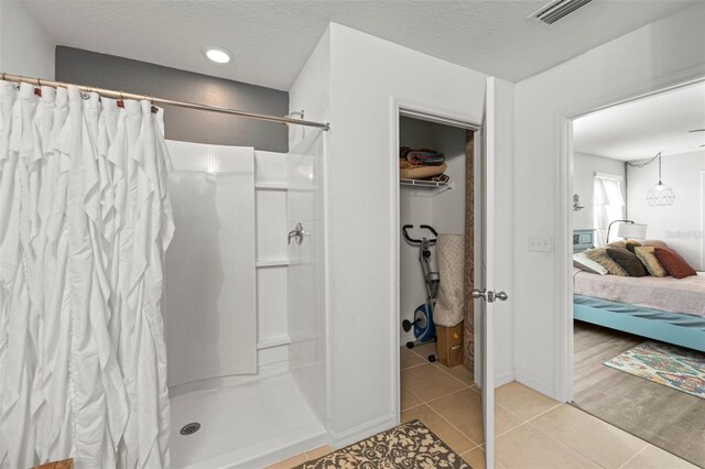 10101 Mangrove Well Rd, Ruskin, FL 33573 - full bath featuring visible vents, a shower with shower curtain, a textured ceiling, ensuite bath, and tile patterned flooring