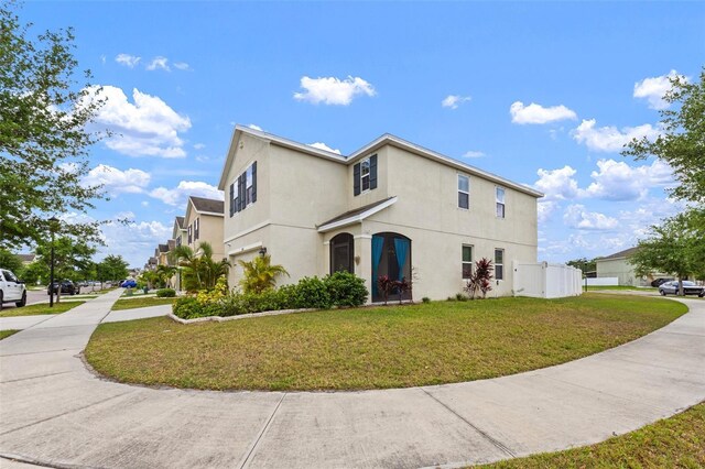 10101 Mangrove Well Rd, Ruskin, FL 33573 - view of side of property with stucco siding and a lawn