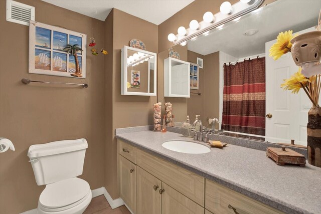 bathroom with vanity, baseboards, tile patterned floors, toilet, and visible vents