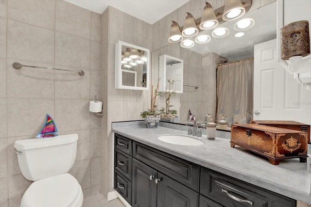 bathroom featuring toilet, vanity, a shower with shower curtain, and tile walls