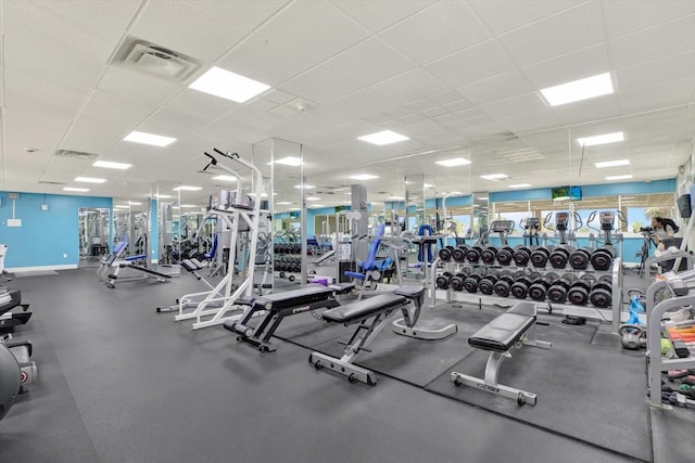 workout area with visible vents, baseboards, and a paneled ceiling