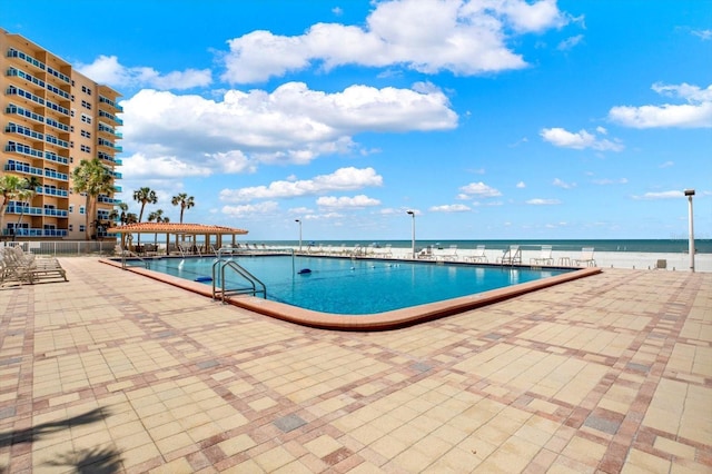 pool with a water view and a patio area