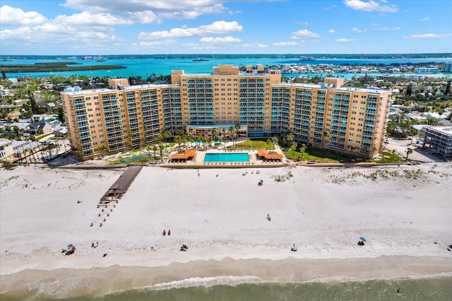 drone / aerial view featuring a water view, a view of the beach, and a city view