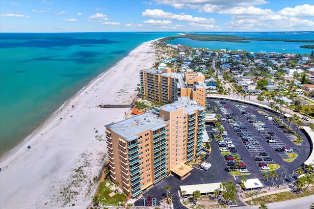 drone / aerial view featuring a water view, a beach view, and a city view
