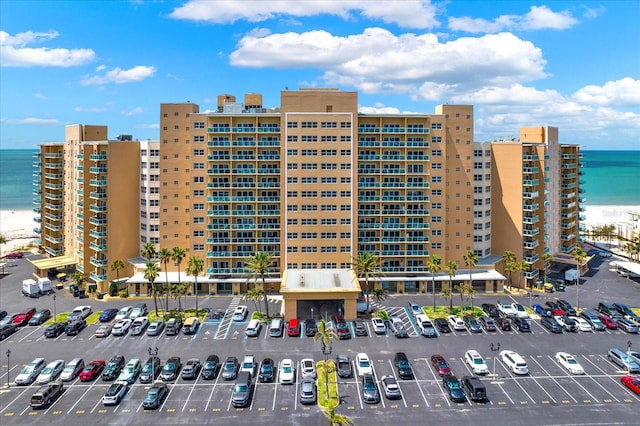 view of building exterior with a water view and uncovered parking