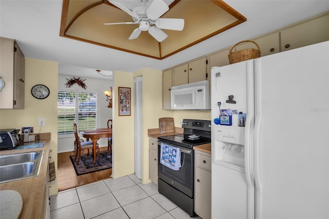 4819 Boonesboro Ct, New Port Richey, FL 34655 - kitchen with a raised ceiling, white appliances, light tile patterned floors, cream cabinets, and ceiling fan