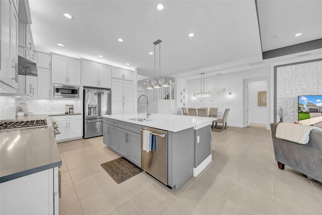 3096 Great Banyan Way, Wesley Chapel, FL 33543 - kitchen with stainless steel appliances, a sink, under cabinet range hood, a chandelier, and backsplash