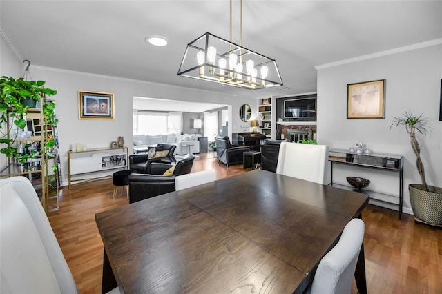 202 S Hesperides St, Tampa, FL 33609 - dining area with crown molding, a chandelier, wood finished floors, recessed lighting, and a fireplace
