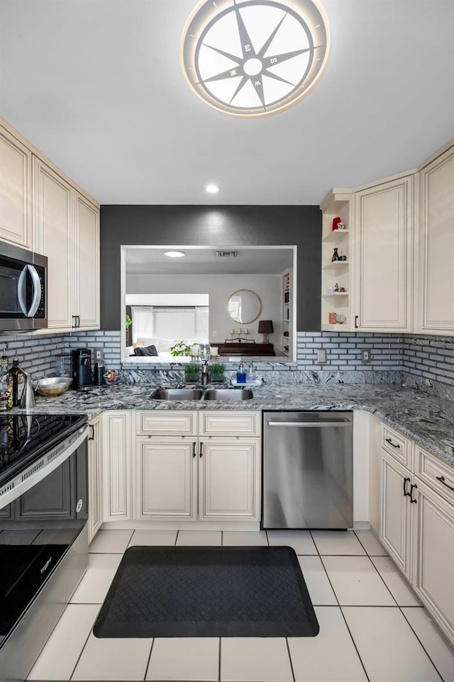 202 S Hesperides St, Tampa, FL 33609 - kitchen featuring appliances with stainless steel finishes, decorative backsplash, cream cabinetry, and open shelves