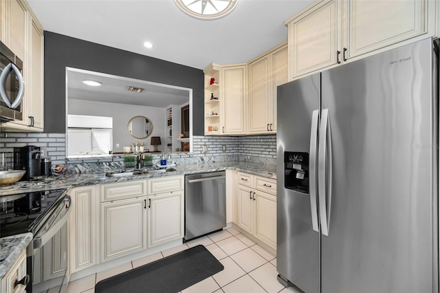 202 S Hesperides St, Tampa, FL 33609 - kitchen featuring appliances with stainless steel finishes, cream cabinets, backsplash, light tile patterned flooring, and recessed lighting