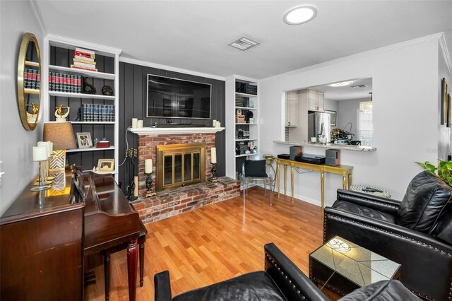 202 S Hesperides St, Tampa, FL 33609 - living area featuring wood finished floors, a fireplace, ornamental molding, and built in shelves