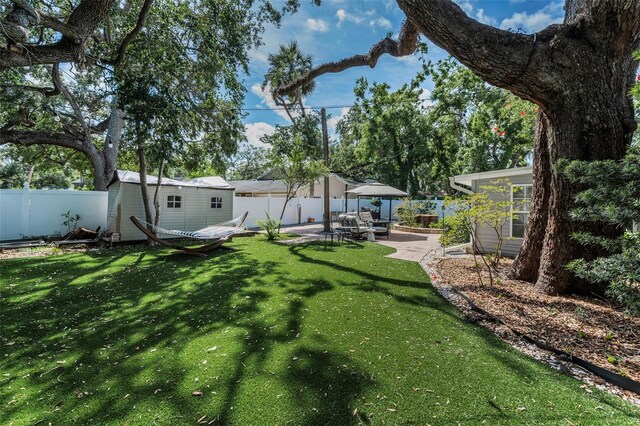 202 S Hesperides St, Tampa, FL 33609 - fenced backyard featuring a patio area and a storage unit