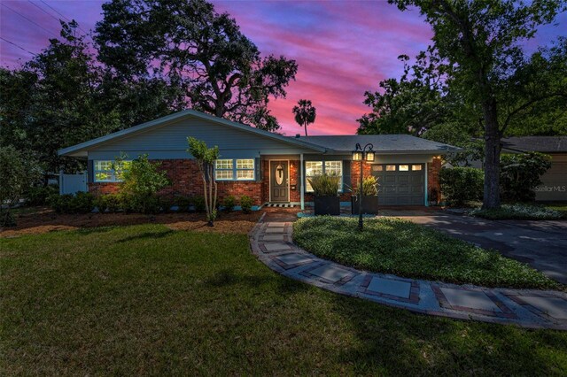 202 S Hesperides St, Tampa, FL 33609 - ranch-style house with brick siding, an attached garage, driveway, and a front yard