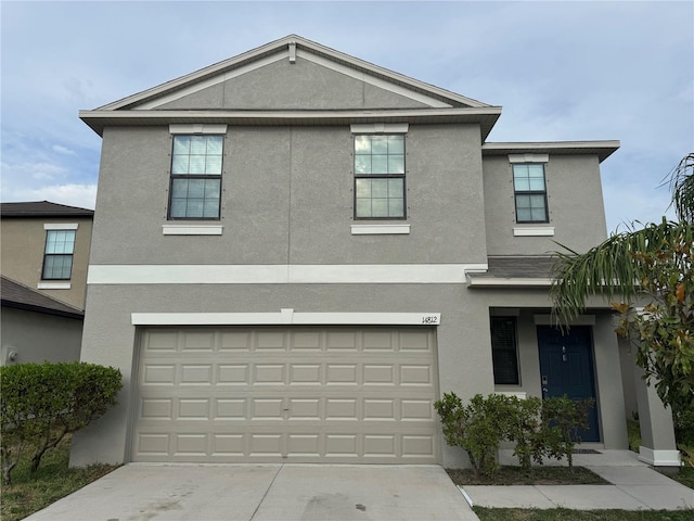 traditional-style home featuring stucco siding, concrete driveway, and a garage