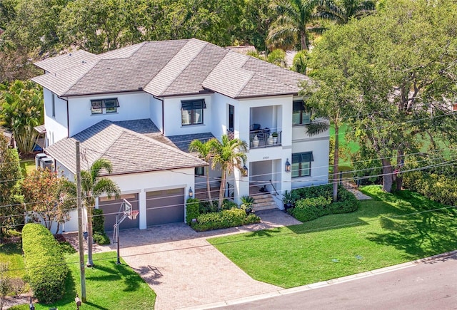 2501 S Dundee St, Tampa, FL 33629 - view of front facade featuring stucco siding, a balcony, decorative driveway, a garage, and a front lawn