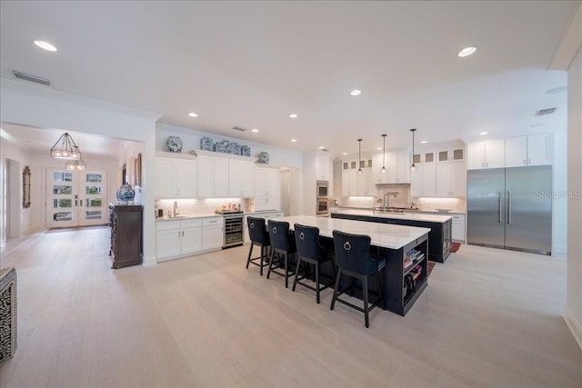 2501 S Dundee St, Tampa, FL 33629 - kitchen with appliances with stainless steel finishes, wine cooler, a large island with sink, decorative backsplash, and recessed lighting