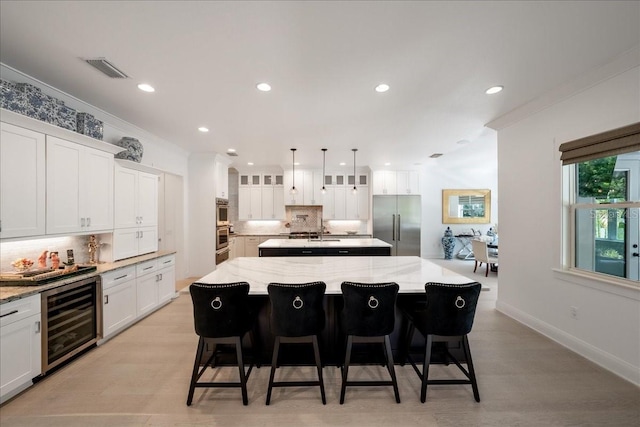 2501 S Dundee St, Tampa, FL 33629 - kitchen with wine cooler, built in refrigerator, a center island with sink, decorative backsplash, and crown molding
