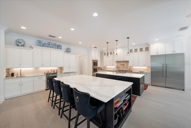 2501 S Dundee St, Tampa, FL 33629 - kitchen featuring a large island, stainless steel appliances, decorative backsplash, recessed lighting, and light wood finished floors