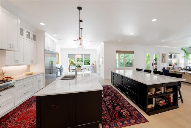 2501 S Dundee St, Tampa, FL 33629 - kitchen with a spacious island, appliances with stainless steel finishes, white cabinetry, a sink, and dark cabinetry