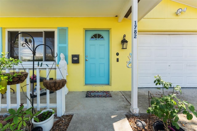 entrance to property featuring stucco siding and an attached garage