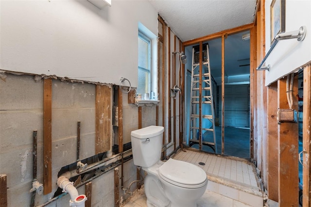 bathroom featuring a textured ceiling and toilet