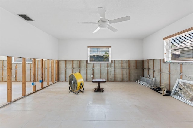 workout room featuring ceiling fan, visible vents, and a wealth of natural light