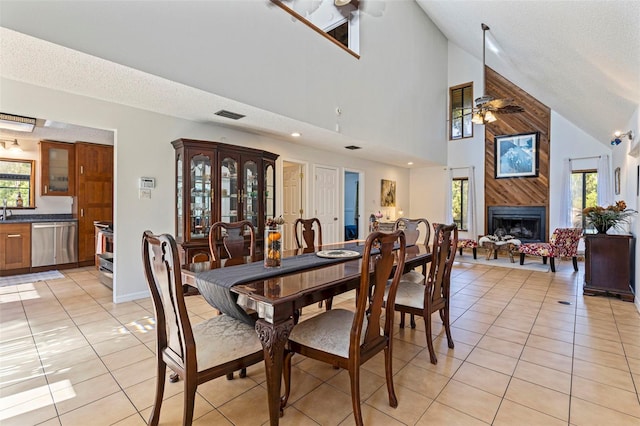 dining space featuring high vaulted ceiling, plenty of natural light, visible vents, and light tile patterned flooring