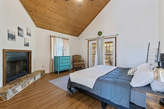 bedroom with baseboards, a stone fireplace, wood ceiling, wood finished floors, and high vaulted ceiling