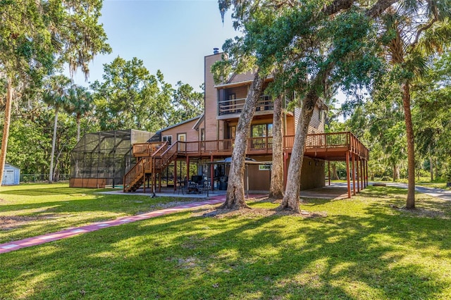 view of jungle gym featuring a yard, a patio area, a deck, and stairs