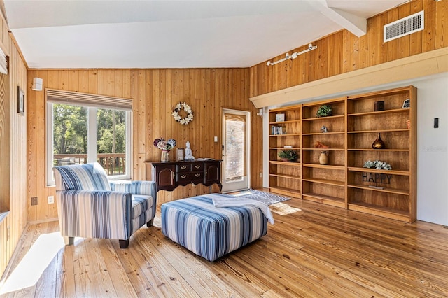 interior space featuring track lighting, wooden walls, wood-type flooring, and visible vents