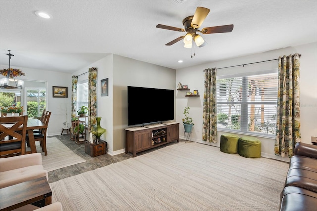 living room with ceiling fan, recessed lighting, plenty of natural light, and baseboards