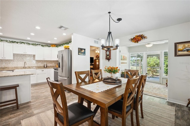 dining area featuring a chandelier, light wood-style floors, visible vents, and recessed lighting