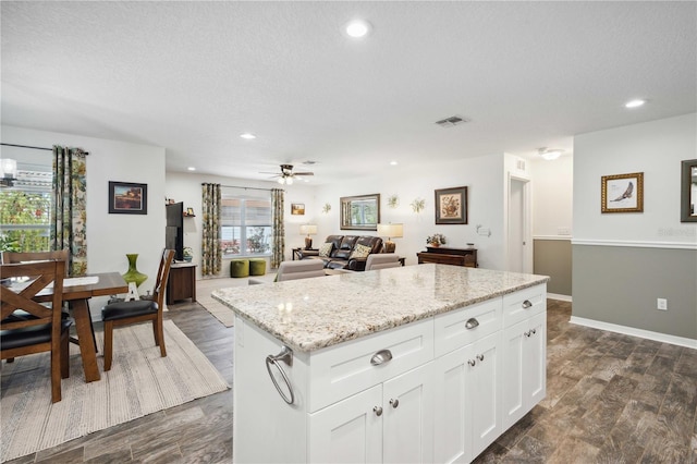 kitchen featuring dark wood finished floors, white cabinetry, visible vents, recessed lighting, and a kitchen island