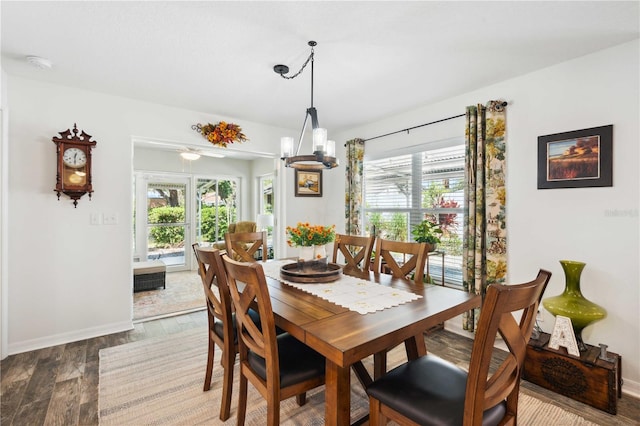 dining area featuring baseboards, a notable chandelier, and wood finished floors