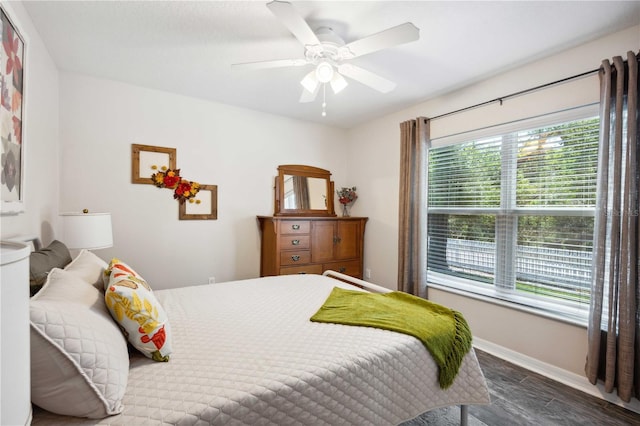 bedroom featuring wood finished floors, baseboards, and a ceiling fan