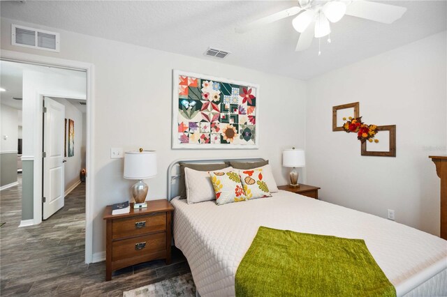 bedroom featuring visible vents, baseboards, ceiling fan, and wood finished floors