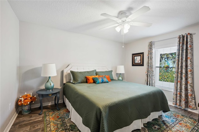 bedroom with baseboards, a ceiling fan, wood finished floors, and a textured ceiling