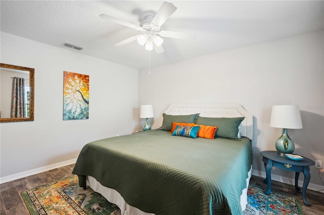 bedroom featuring wood finished floors, baseboards, a ceiling fan, and visible vents