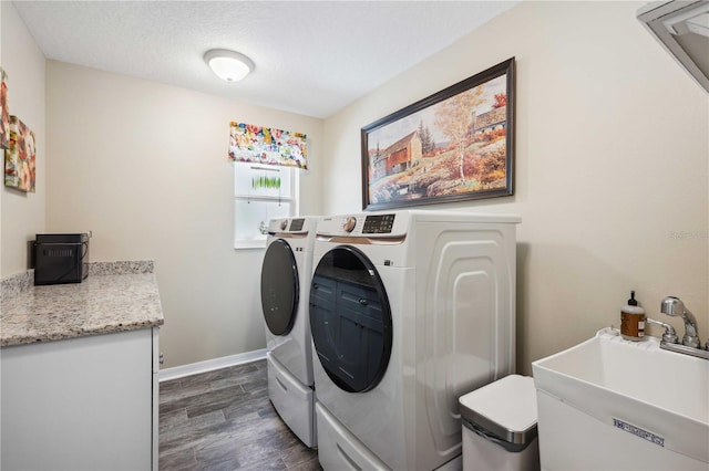 laundry area featuring laundry area, dark wood-style flooring, a sink, baseboards, and washer and clothes dryer