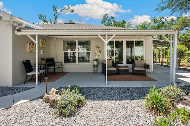 rear view of property with a patio area and stucco siding