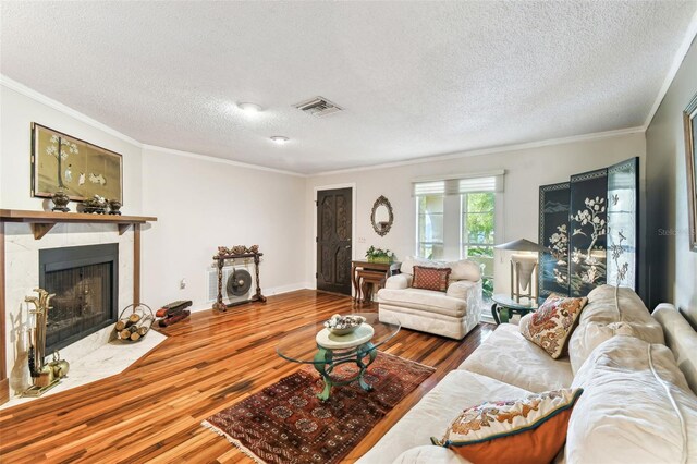 11383 Pickford St, Spring Hill, FL 34609 - living room with visible vents, crown molding, wood finished floors, a textured ceiling, and a tiled fireplace