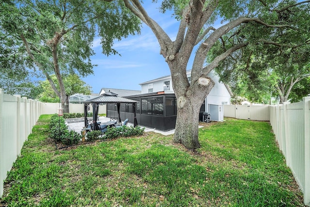 view of yard featuring a sunroom, a gazebo, and a fenced backyard