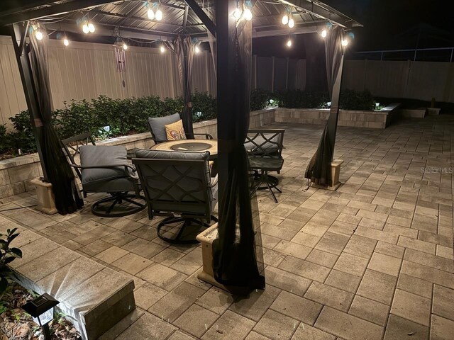 1830 Citrus Orchard Way, Valrico, FL 33594 - patio at night featuring a gazebo, outdoor dining space, and a fenced backyard