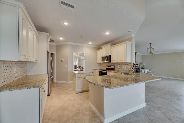 kitchen with a center island, crown molding, visible vents, stainless steel appliances, and a sink