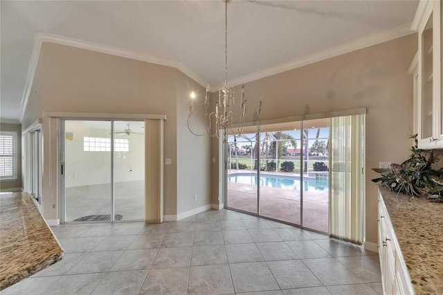unfurnished dining area featuring ornamental molding, baseboards, light tile patterned floors, and ceiling fan with notable chandelier