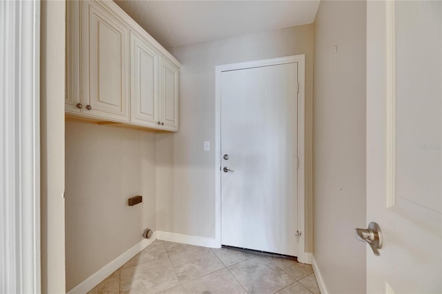 laundry area featuring laundry area, light tile patterned flooring, and baseboards