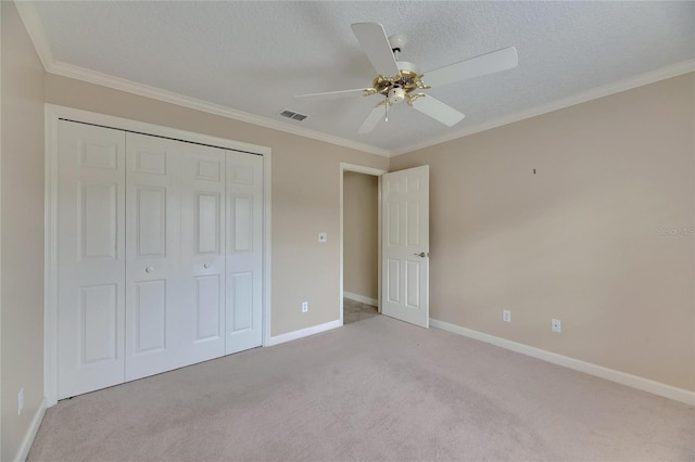 unfurnished bedroom featuring crown molding, a closet, baseboards, and light carpet
