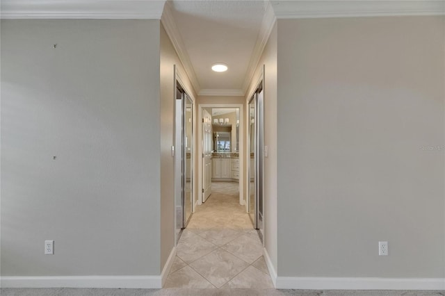 corridor with crown molding and baseboards