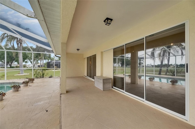 view of patio with an outdoor pool and glass enclosure