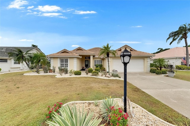 view of front of house featuring stucco siding, driveway, a front lawn, a tile roof, and a garage